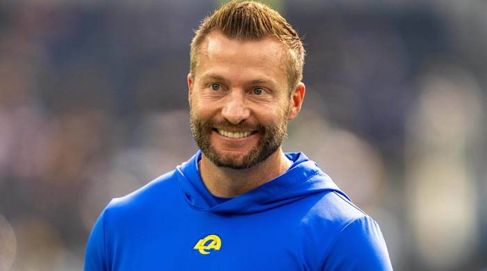 Los Angeles Rams head coach Sean McVay smiles while on the field before a game.